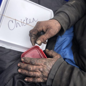 hands of homeless man with delivered meal