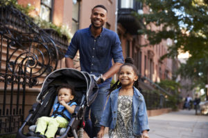 Father and two children taking a walk down the street, close up