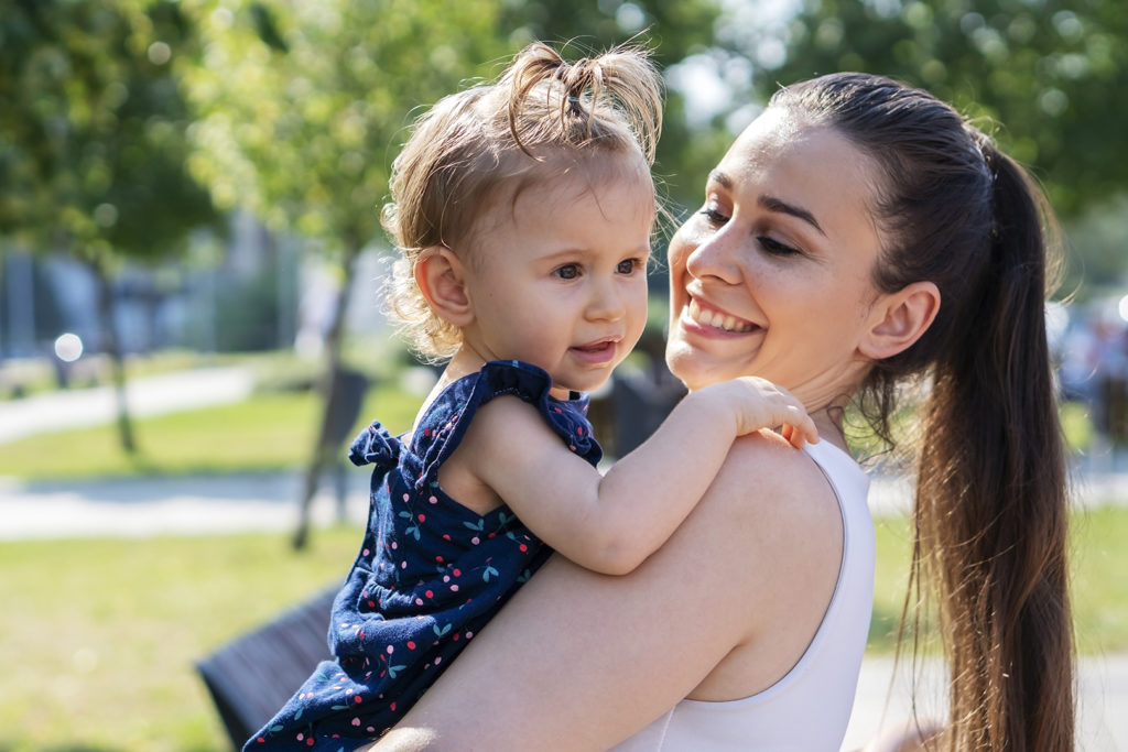 Mother plays with her daughter in a park