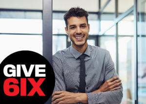 Happy young man in an office with GIVE 6IX logo