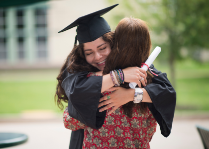 Image of university graduate hugging a woman