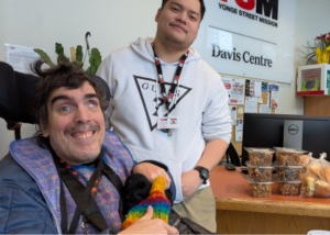 Image of Adrian at the Bridges reception desk with donated food